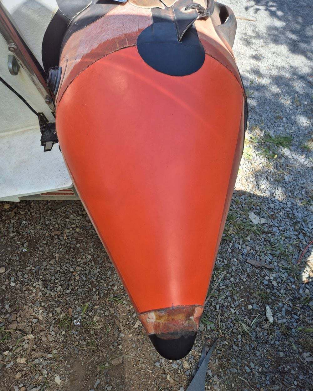 Étrave de bateau repeinte en orange, surface lisse et brillante
