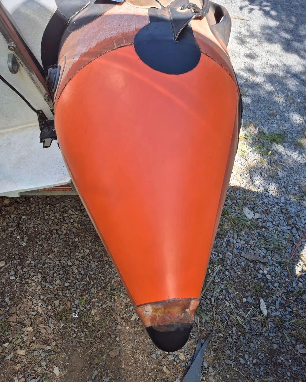 Étrave de bateau repeinte en orange, surface lisse et brillante